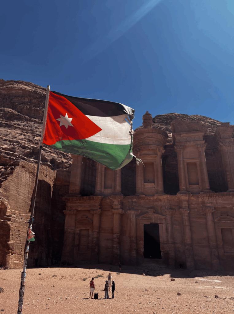 a Jordanian flag waves proudly over the monastery in petra